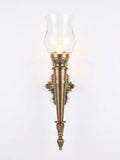 Ornate Torch Hurricane Sconce, a brass and glass wall light, studio photograph on a white background