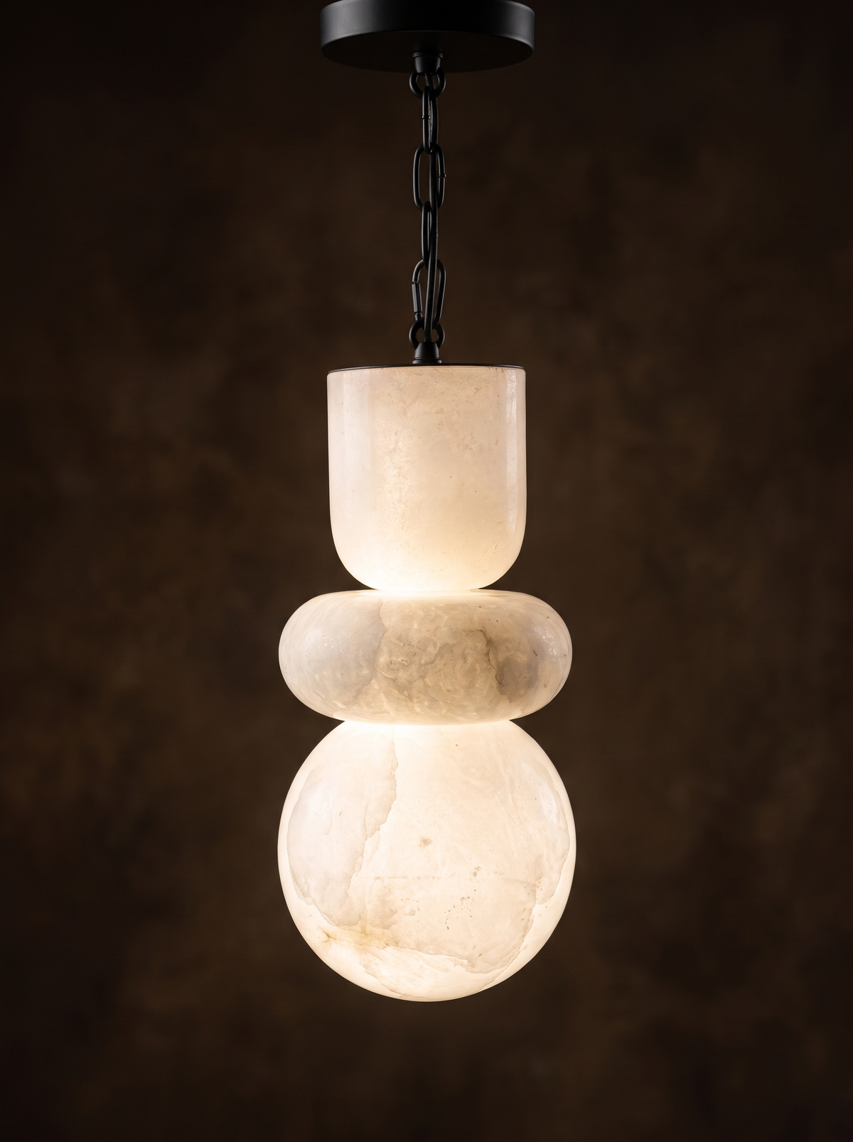 Alabaster Stack Pendant Light switched on, the veined alabaster glowing warm white from within
