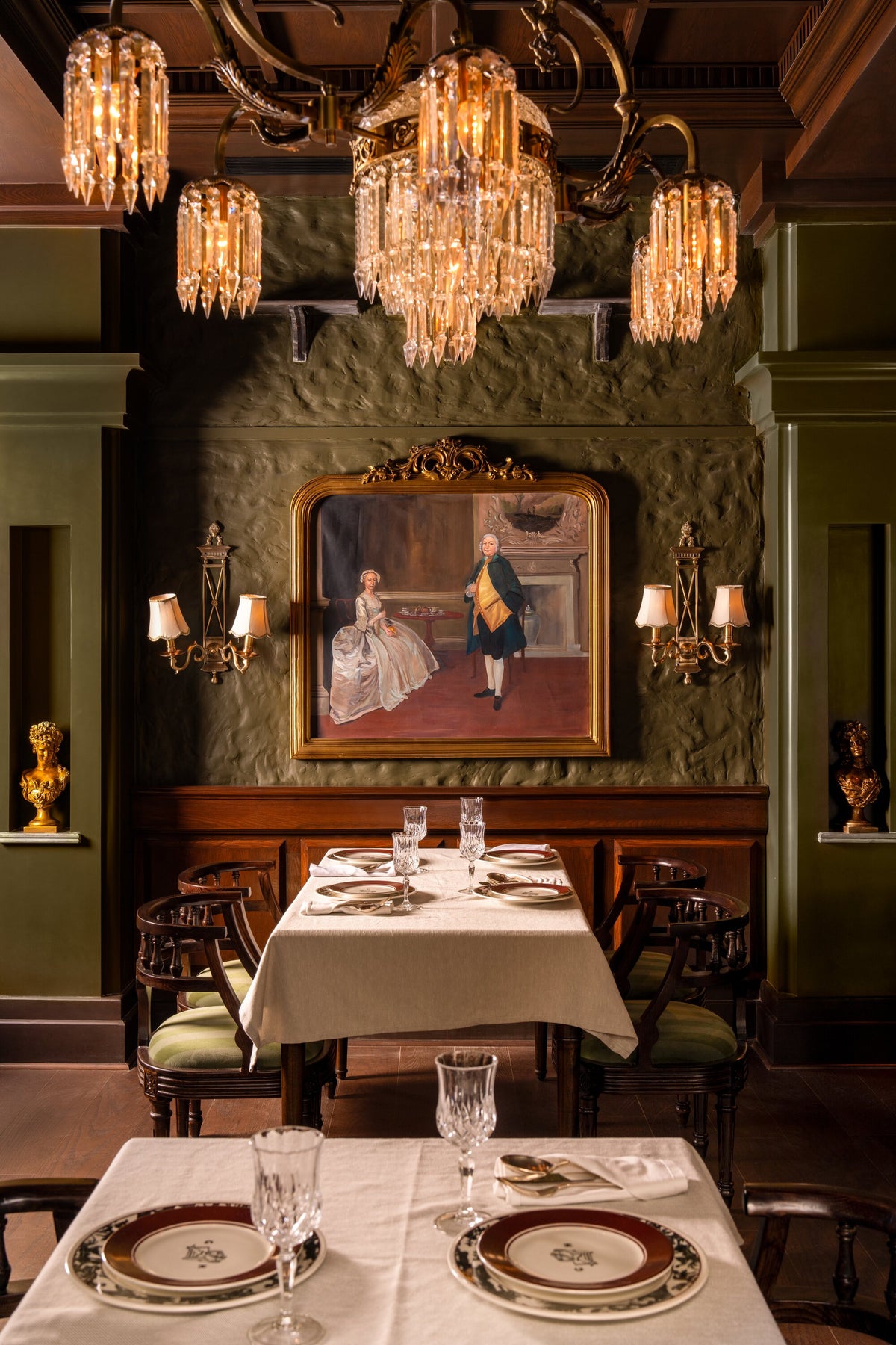 Brass and crystal prism chandelier and Directoire wall lights on a green portrait wall at The Governor House, Amritsar – Renesa Architecture Studio, photo Avesh Gaur