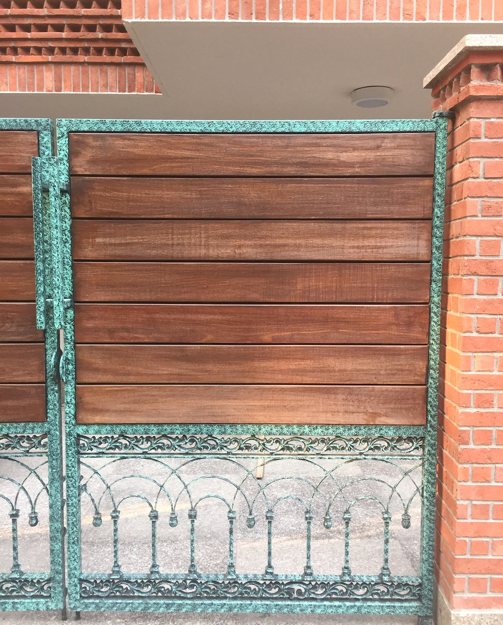 Detail of wood and green patina cast metal gate