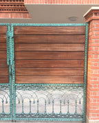 Detail of wood and green patina cast metal gate