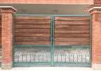 Wood gate with green patina cast metal arches and borders