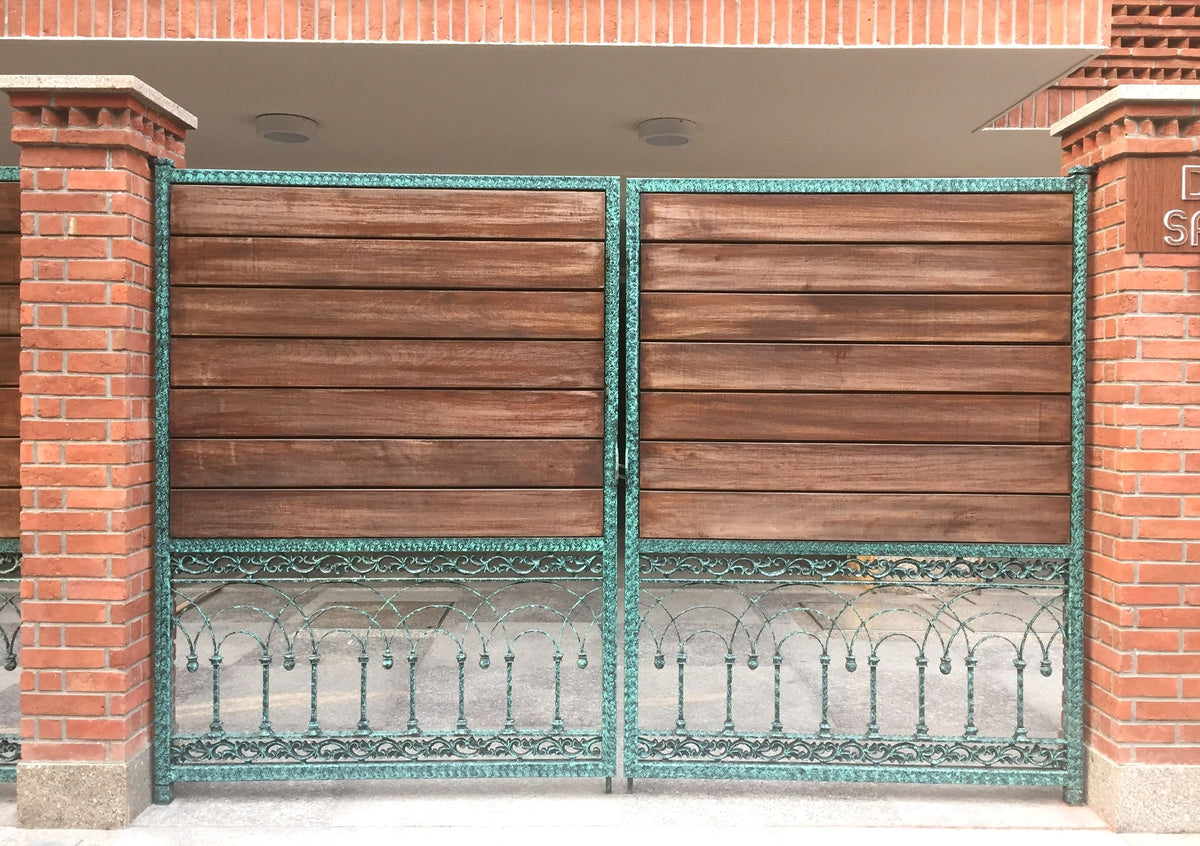 Wood gate with green patina cast metal arches and borders