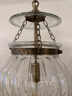 Close-up of the cut-glass smoke plate, brass chains and hand-embossed repoussé brass band on the ribbed glass globe