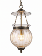 Repoussé Brass Lantern Pendant lit, the ribbed glass glowing warm