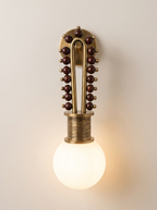 Mala Wall Light switched on, the frosted glass globe glowing warm