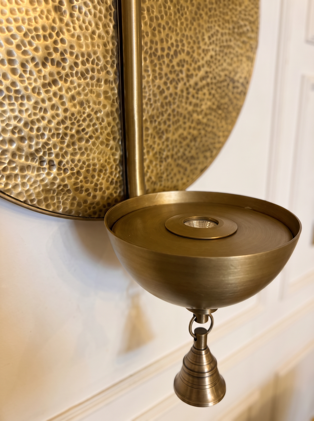 Close-up of the hammered brass disc, the brass bowl with its LED spot and the small temple bell