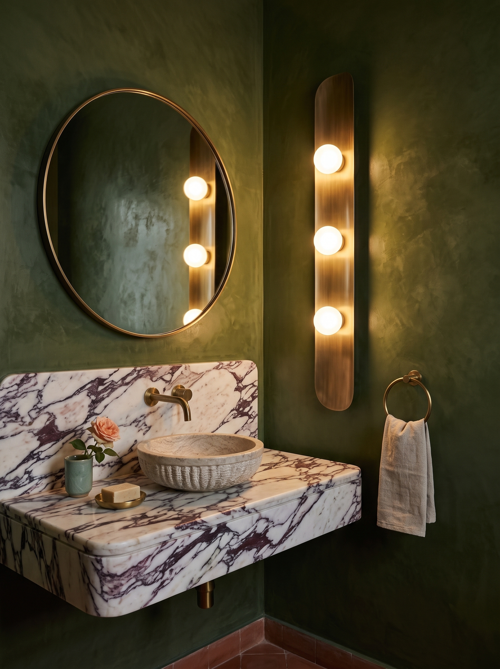 Reed Wall Light glowing beside a round brass mirror in an olive green tadelakt powder room with a Calacatta Viola marble vanity