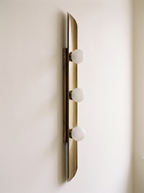 Reed Wall Light side view, showing the shallow curve of the brass sheet, the slanted end and the slim backbar