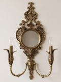 Rococo Mirror Double Wall Light, pierced cast antique brass scrollwork around a round mirror with two candle arms, front view
