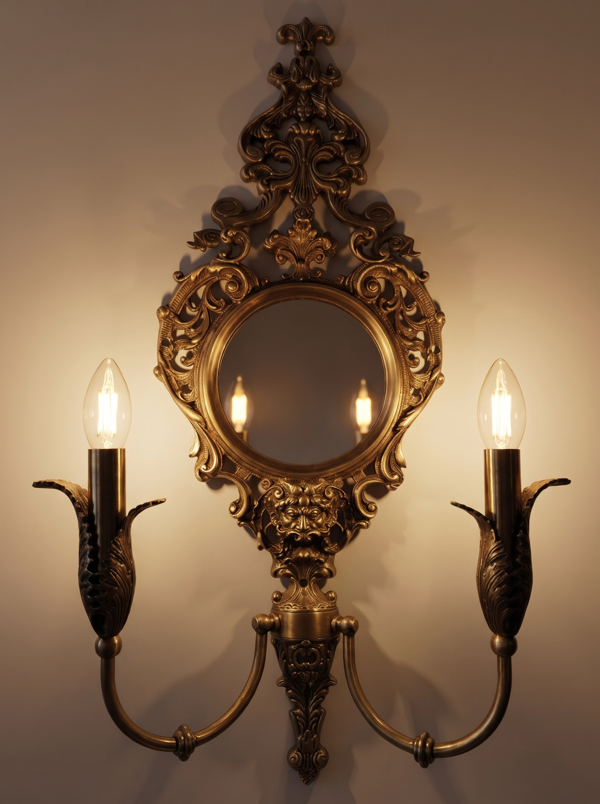 Rococo Mirror Double Wall Light switched on, two candle bulbs glowing and reflected in the round mirror