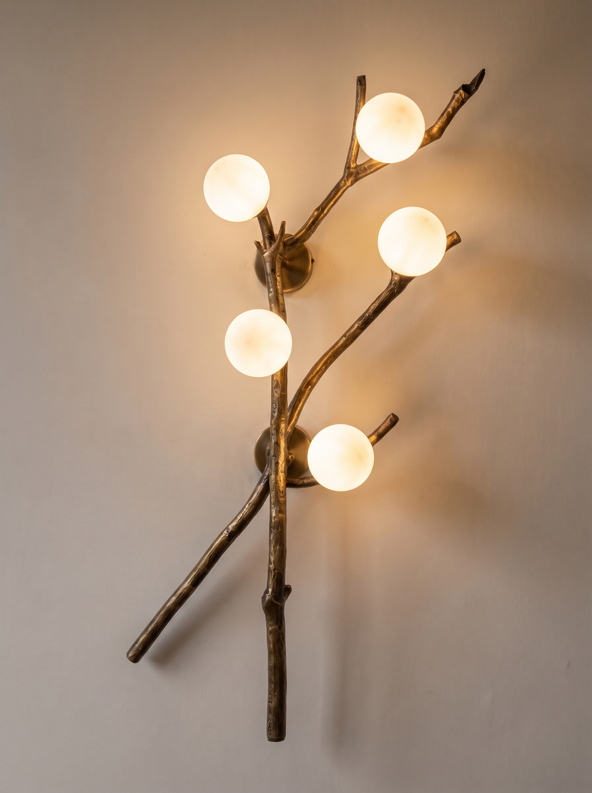 Shakha Branch Wall Light switched on, five globes glowing and casting branch shadows on the wall
