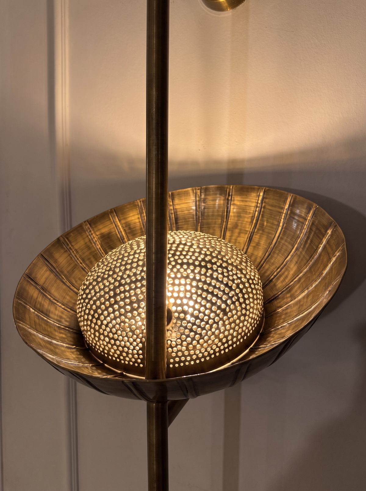 Close-up of the large hand-etched brass bowl, its dotted inner dome sparkling with light