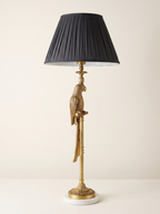 Brass Parrot Table Lamp with a cast brass parrot on a slim column, white marble base and pleated charcoal shade, front view